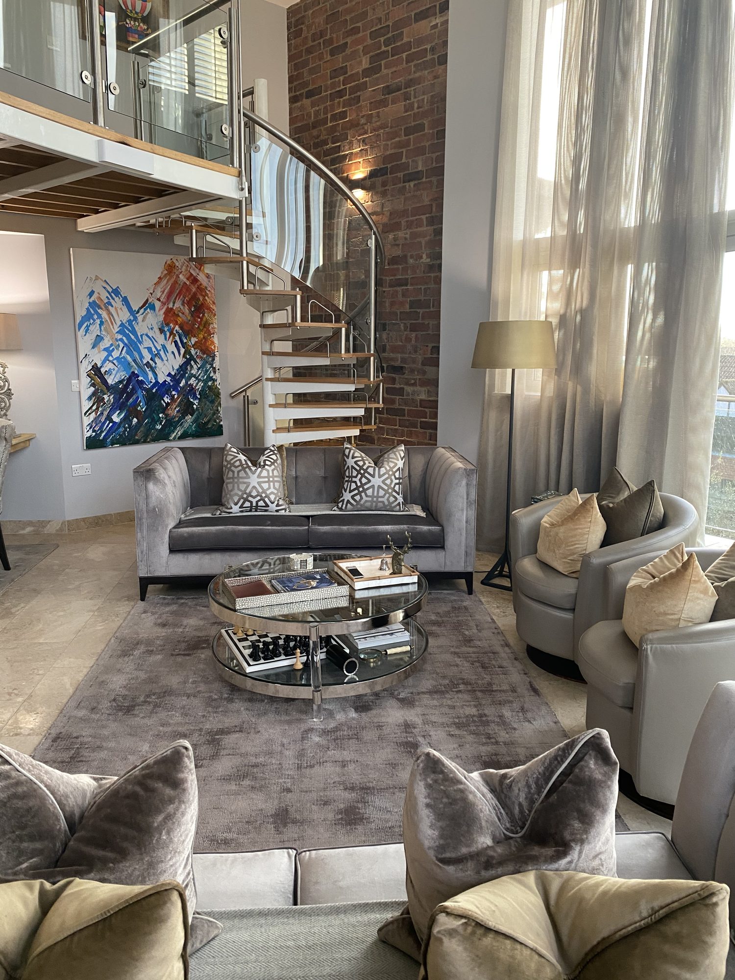 Double-height living room with sofa and spiral staircase