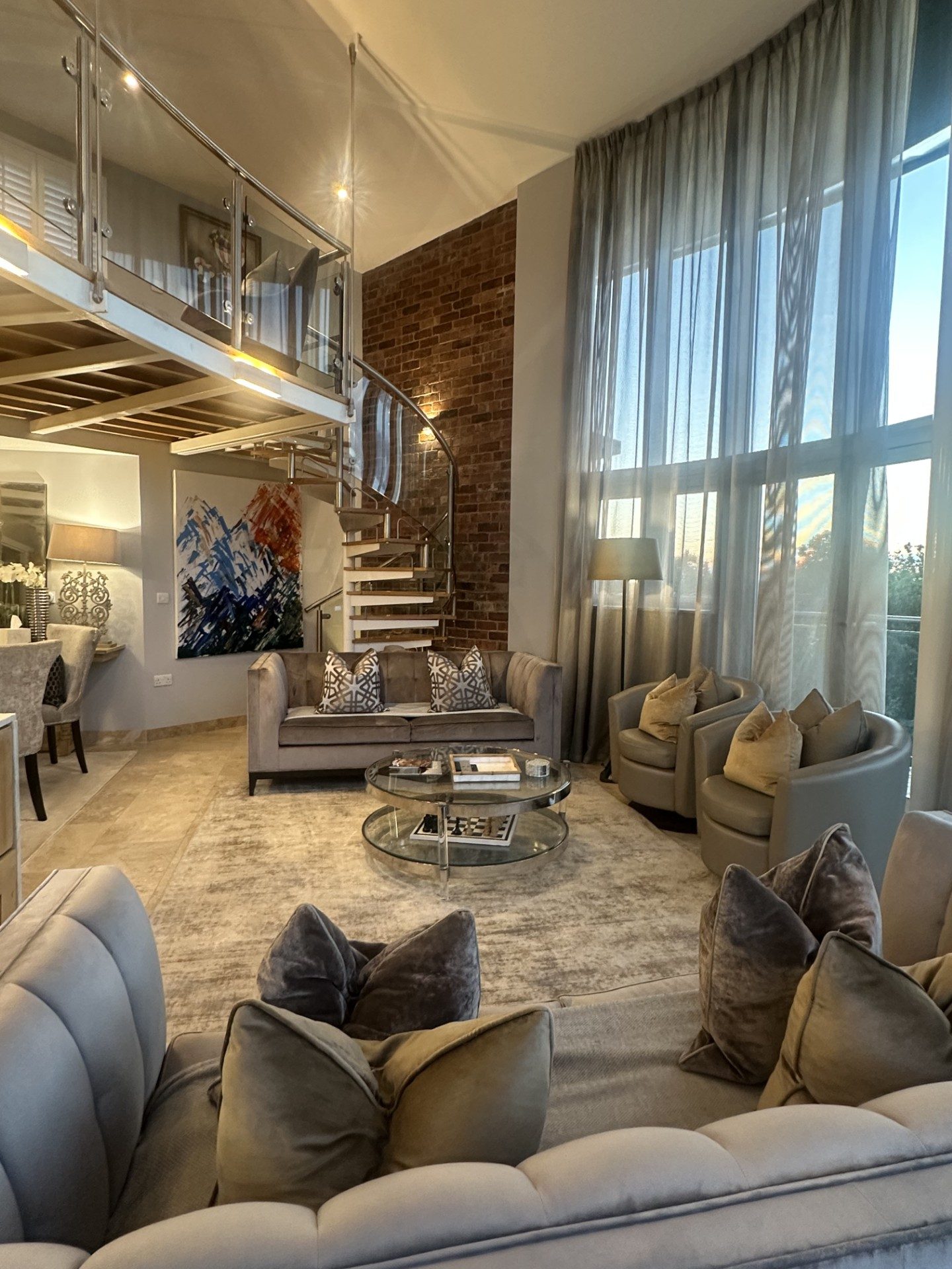 Double-height lounge at dusk with floor-to-ceiling windows