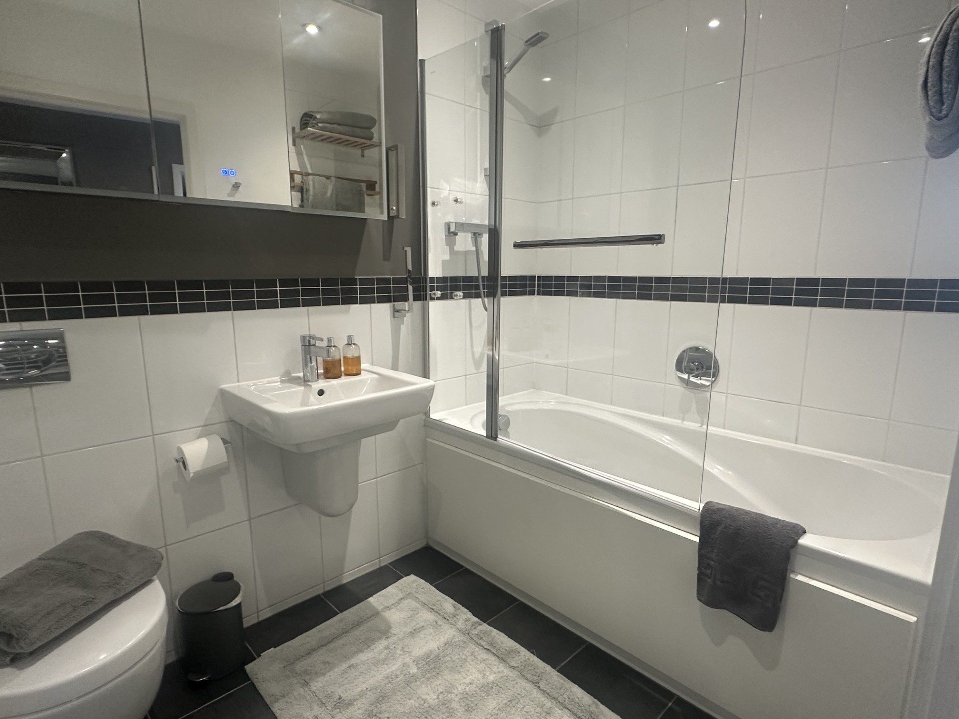 Bathroom with bath, overhead shower and glass screen