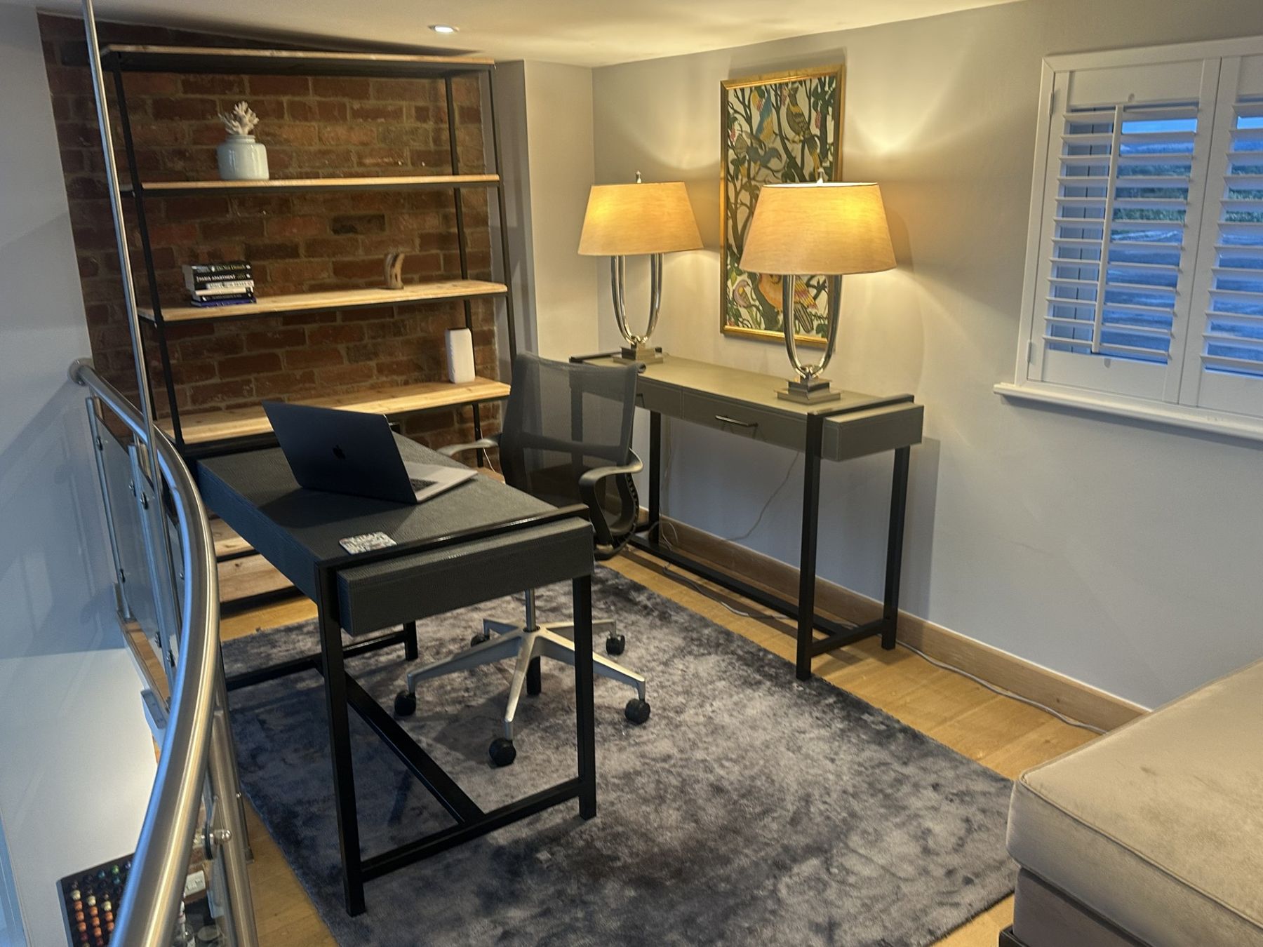 Desk against exposed brick with open shelving